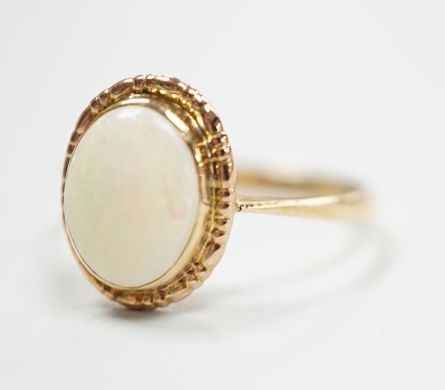 A yellow metal and oval white opal set ring, size Q, gross weight 2 grams.